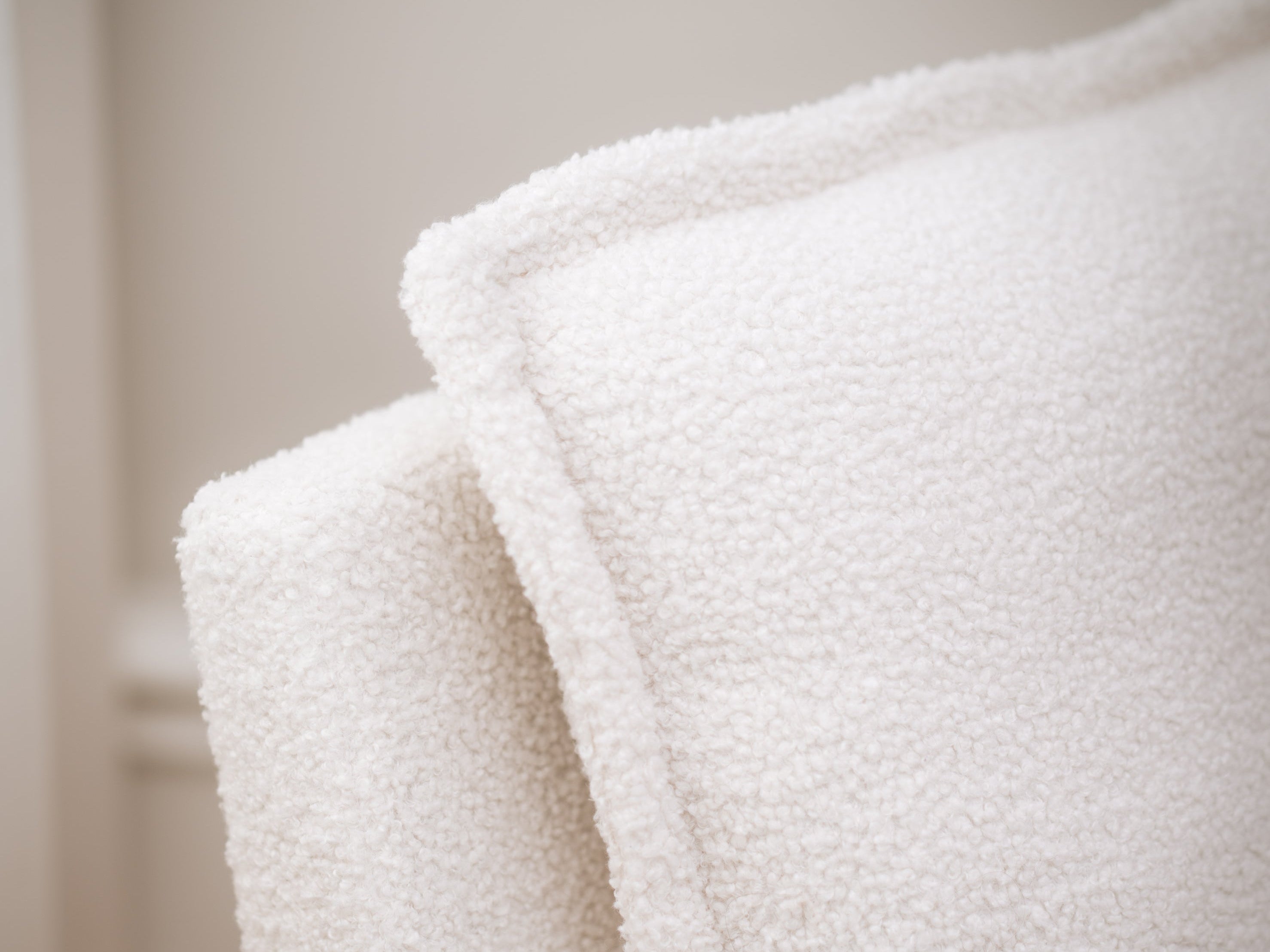 Close-up of a textured white blanket with a blurred background