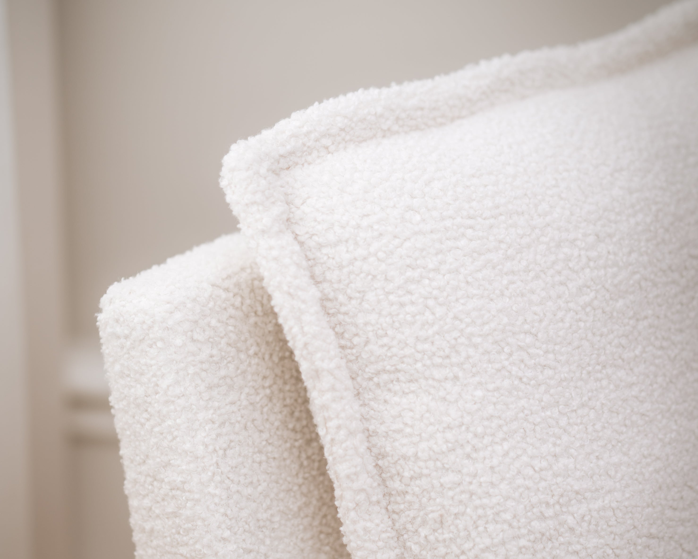 Close-up of a textured white blanket with a blurred background